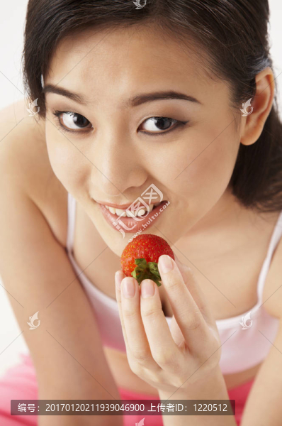 年輕的女人吃草莓
