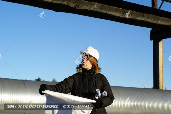 年輕建筑師在藍天前建筑工地看藍圖