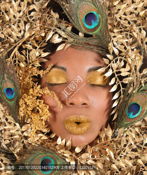 裹著金屬葉子和孔雀羽毛的女人