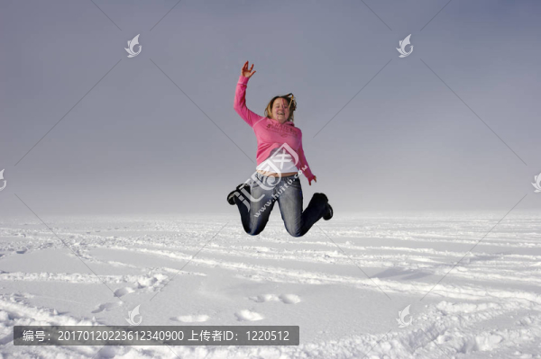 女人在冬季跳到空中