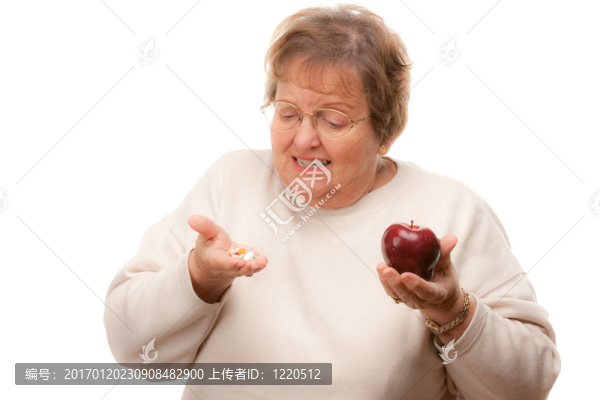 困惑的高級婦女持有蘋果和維生素