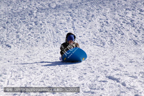 小男孩坐雪橇滑下Hill