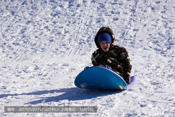 小男孩坐雪橇滑下Hill