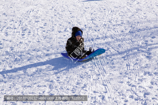 小男孩坐雪橇滑下Hill