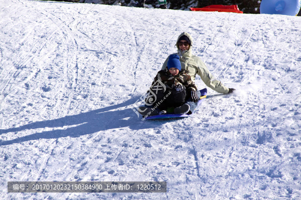 母親和兒子坐雪橇滑下Hill