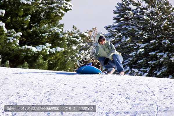 母親和兒子坐雪橇滑下Hill