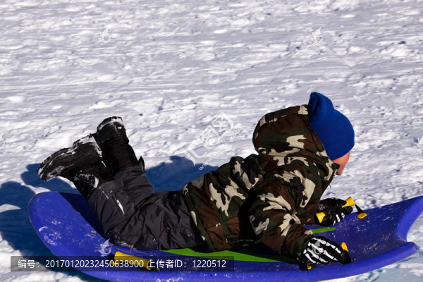 小男孩坐雪橇滑下Hill