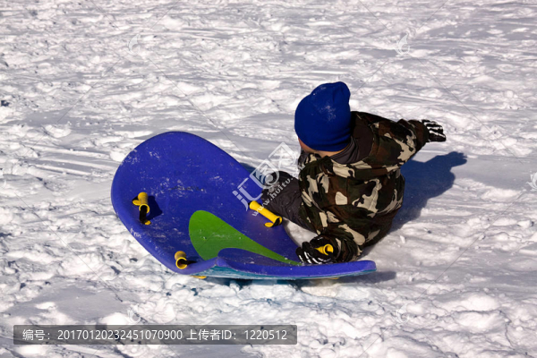 小男孩坐雪橇滑下Hill