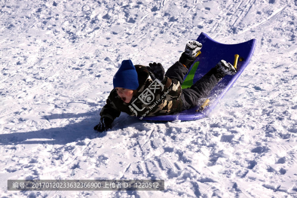 小男孩坐雪橇滑下Hill