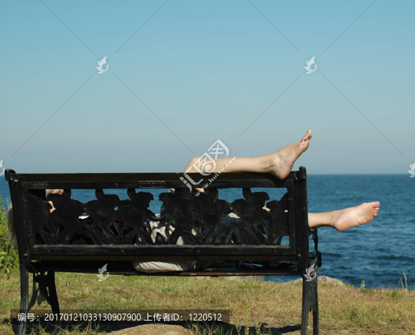 裸腳懸在靠近海洋的長(zhǎng)椅上