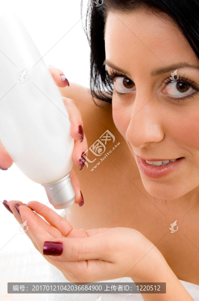 在一個(gè)孤立的白色背景下，年輕女性手拿乳液