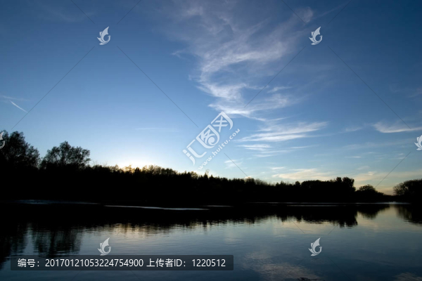 黃昏的樹線倒影在水面上
