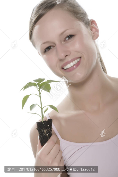 美麗的金發(fā)女孩抱著年輕的植物