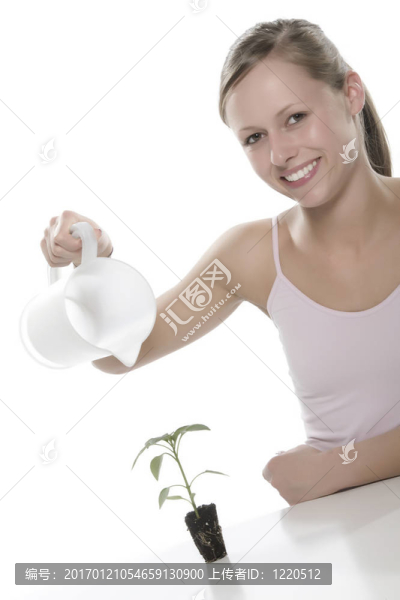 美麗的金發(fā)女孩抱著年輕的植物