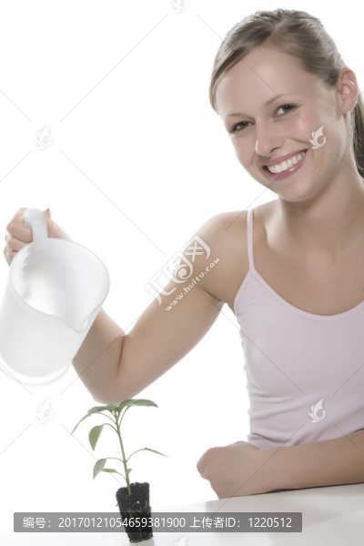 美麗的金發(fā)女孩抱著年輕的植物