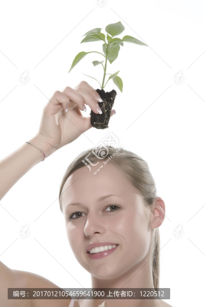 美麗的金發(fā)女孩抱著年輕的植物