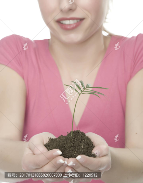 美麗的金發(fā)女孩抱著年幼的植物