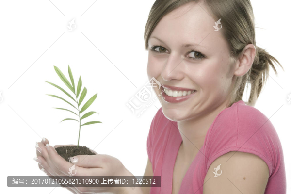 美麗的金發(fā)女孩抱著年幼的植物