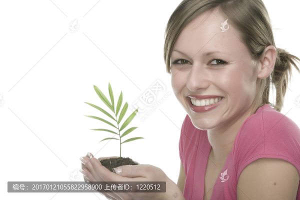 美麗的金發(fā)女孩抱著年幼的植物