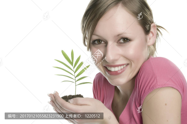 美麗的金發(fā)女孩抱著年幼的植物