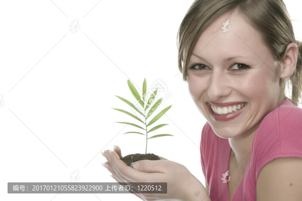 美麗的金發(fā)女孩抱著年幼的植物