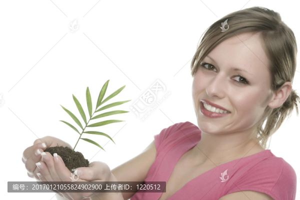 美麗的金發(fā)女孩抱著年幼的植物
