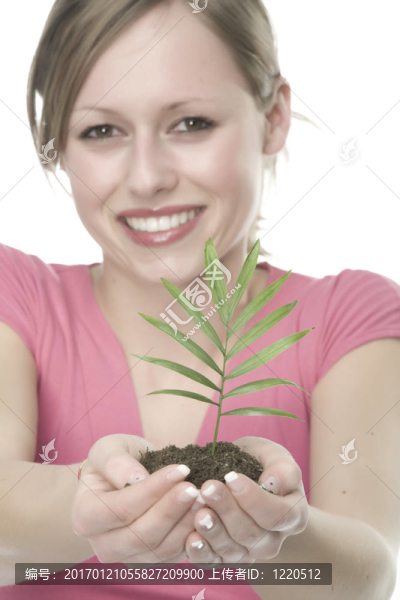 美麗的金發(fā)女孩抱著年幼的植物