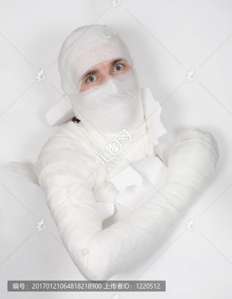 把繃帶從紙上的洞里抽出來的男孩