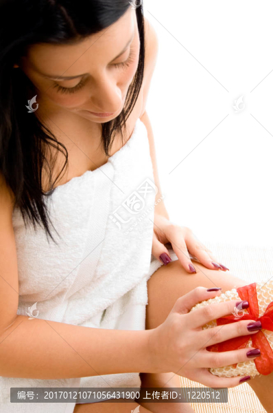女人用白色背景擦洗身體的俯視圖