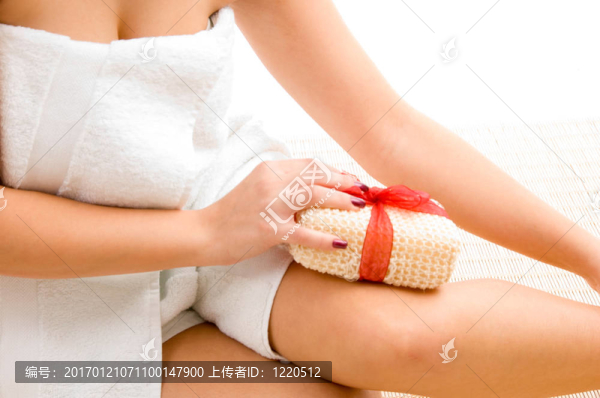 女性在白色背景上擦拭腿部的特寫鏡頭