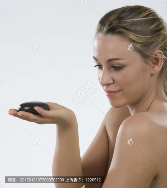 石療法。年輕女子手上有一塊石頭