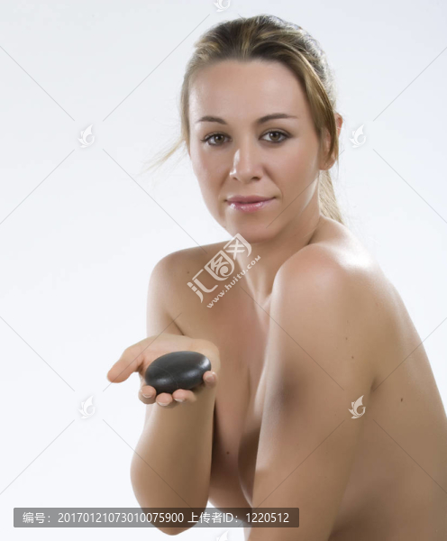 石療法。年輕女子手上有一塊石頭