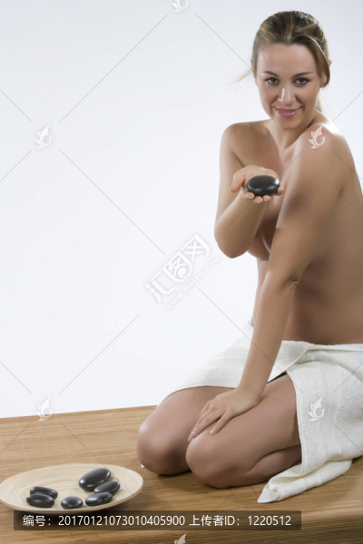 石療法。年輕女子手上有一塊石頭