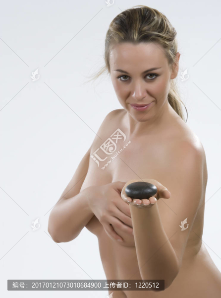石療法。年輕女子手上有一塊石頭