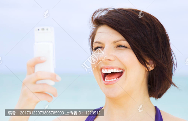 快樂(lè)的女人在海灘上的電話