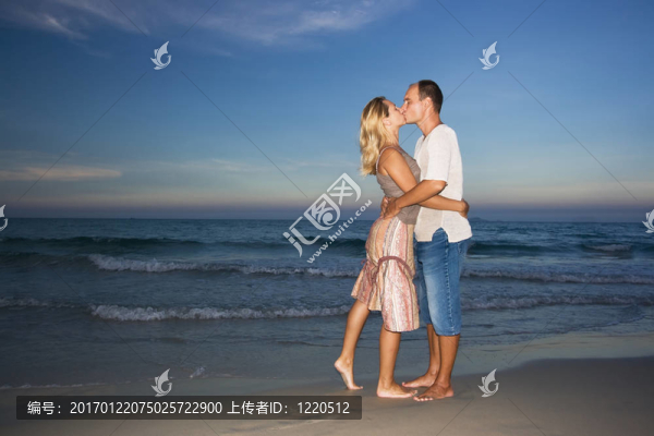 年輕夫婦在海洋附近接吻