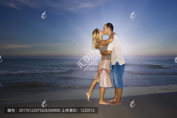 年輕夫婦在海洋附近接吻