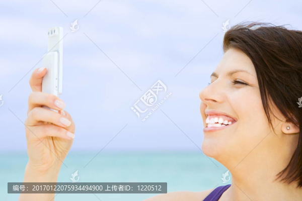 快樂的女人在海灘上的電話
