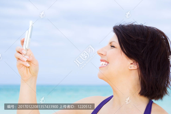 快樂(lè)的女人在海灘上的電話