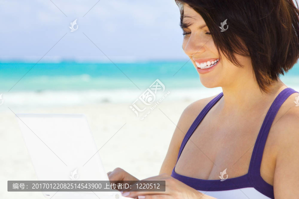 海灘上帶著筆記本電腦的女人