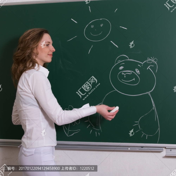 年輕的女人在黑板上畫畫。