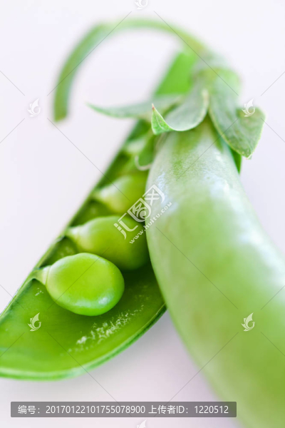 白色桌子上的綠色豌豆莢