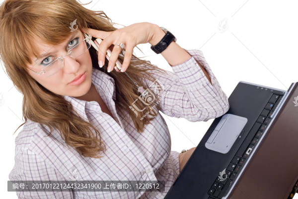 戴眼鏡的年輕女子坐在筆記本電腦和電話旁。分離