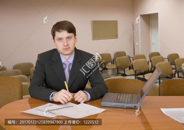商人在一張有筆記本電腦的桌子上