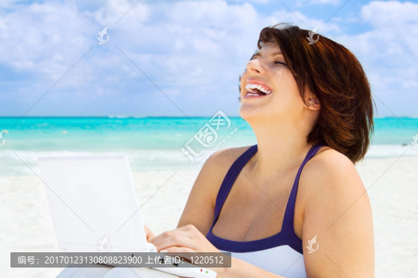 海灘上帶著筆記本電腦的女人