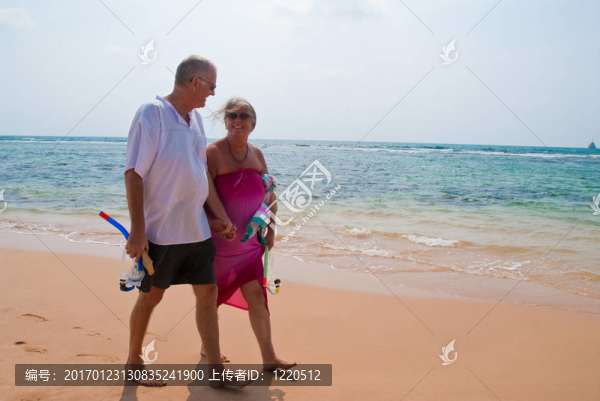 成熟的夫婦在海灘上散步