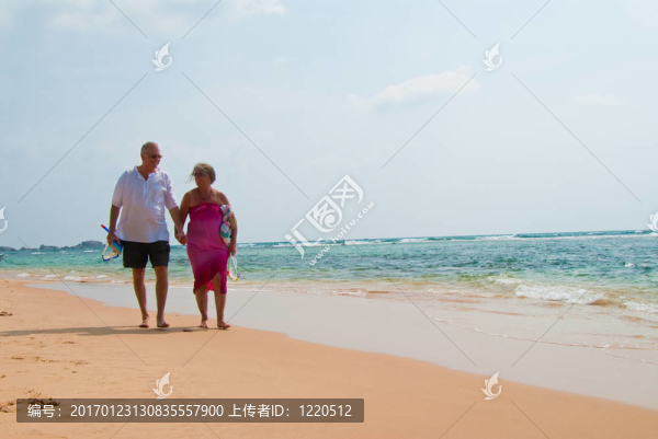 成熟的夫婦在海灘上散步