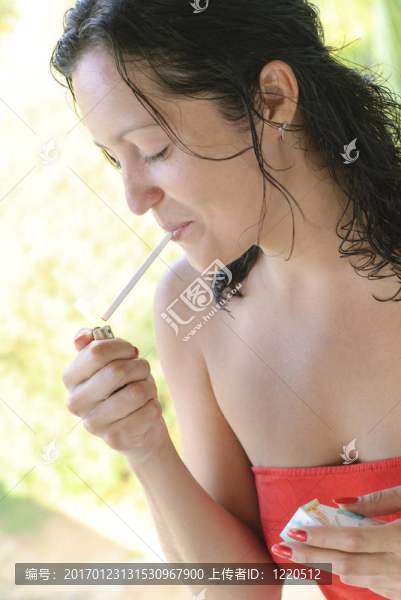 美麗的年輕女人點燃香煙