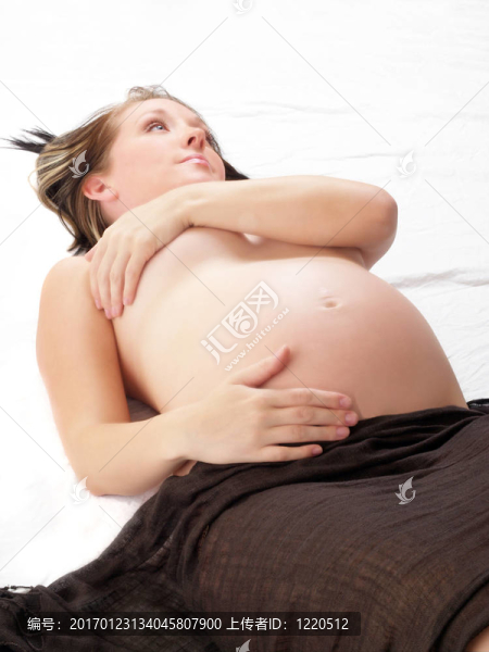 年輕金發(fā)孕婦裸露在地板上的肚子