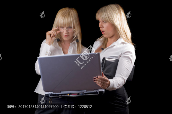 兩個年輕婦女與筆記本電腦。孤立的黑色